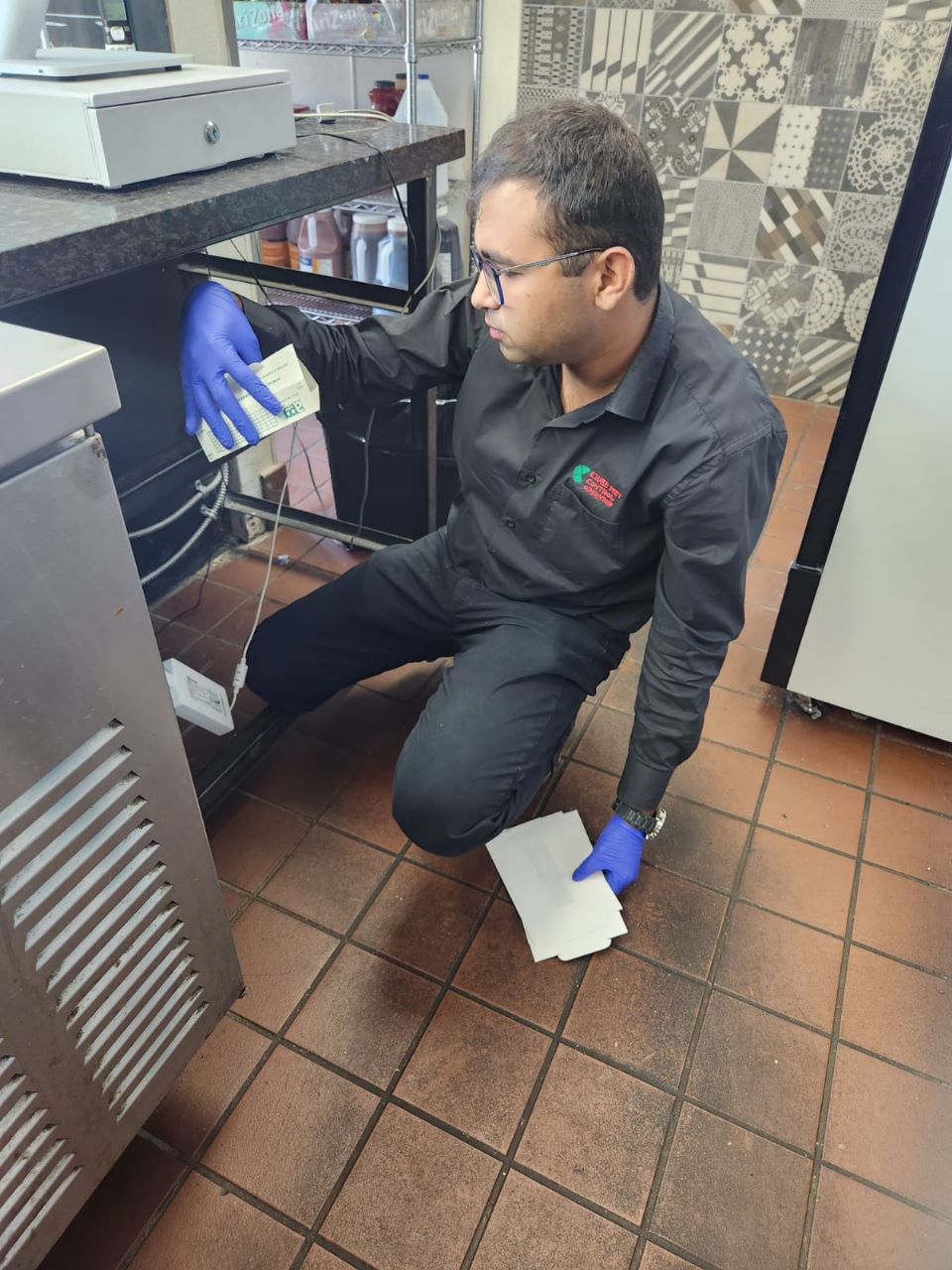 Technicien d'Chase Pest Control Operator en train d'inspecter une cuisine de restaurant